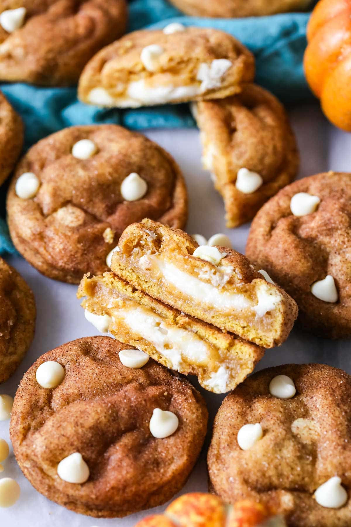 Overhead view of pumpkin cheesecake cookies with the center cookie cut in half to show the filling.