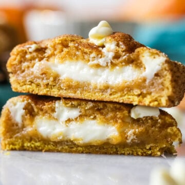 Two halves of a pumpkin cheesecake cookie stacked on top of each other.