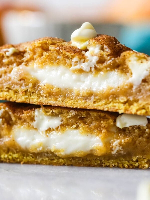 Two halves of a pumpkin cheesecake cookie stacked on top of each other.