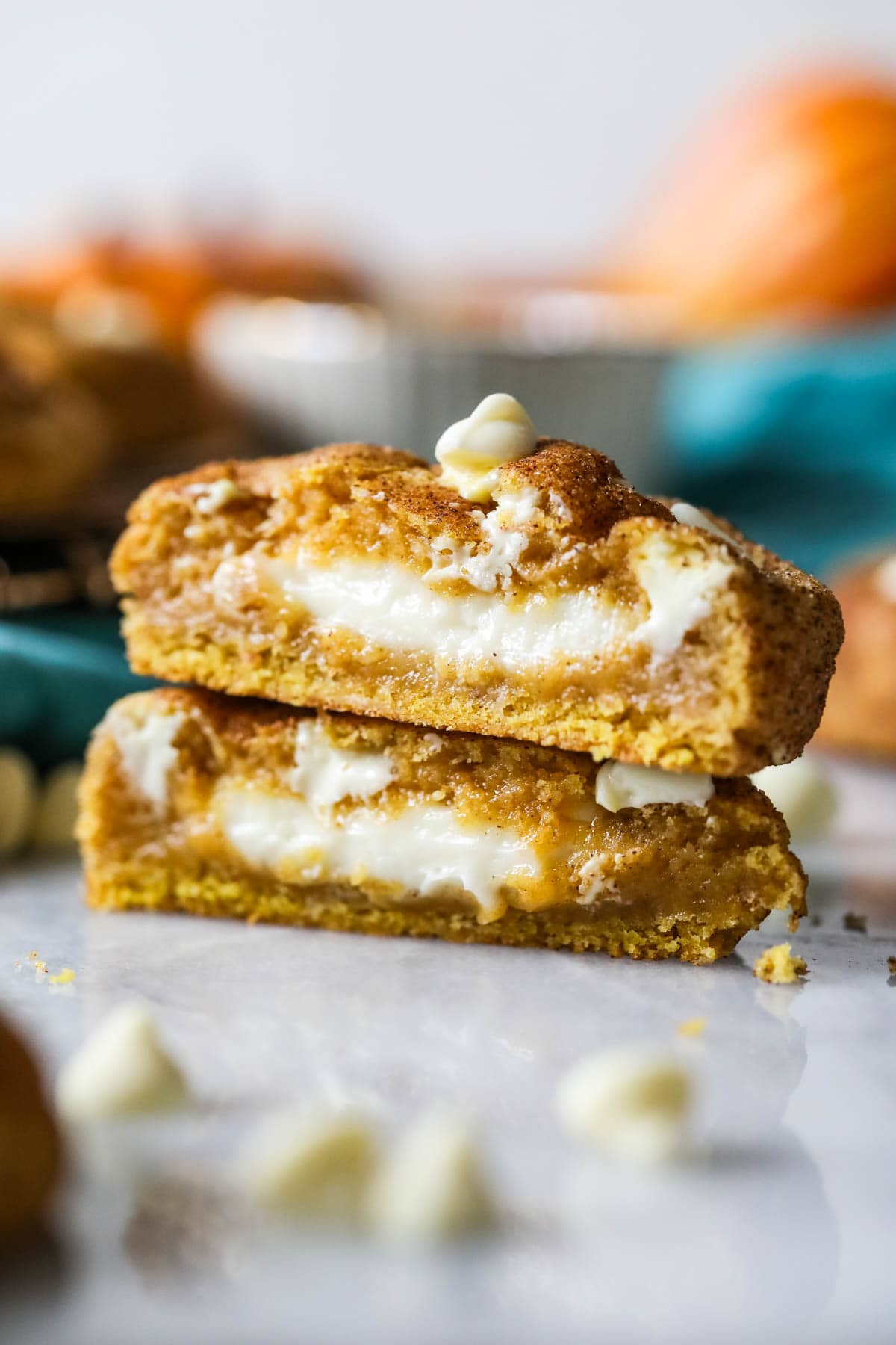 Two halves of a pumpkin cheesecake cookie stacked on top of each other.