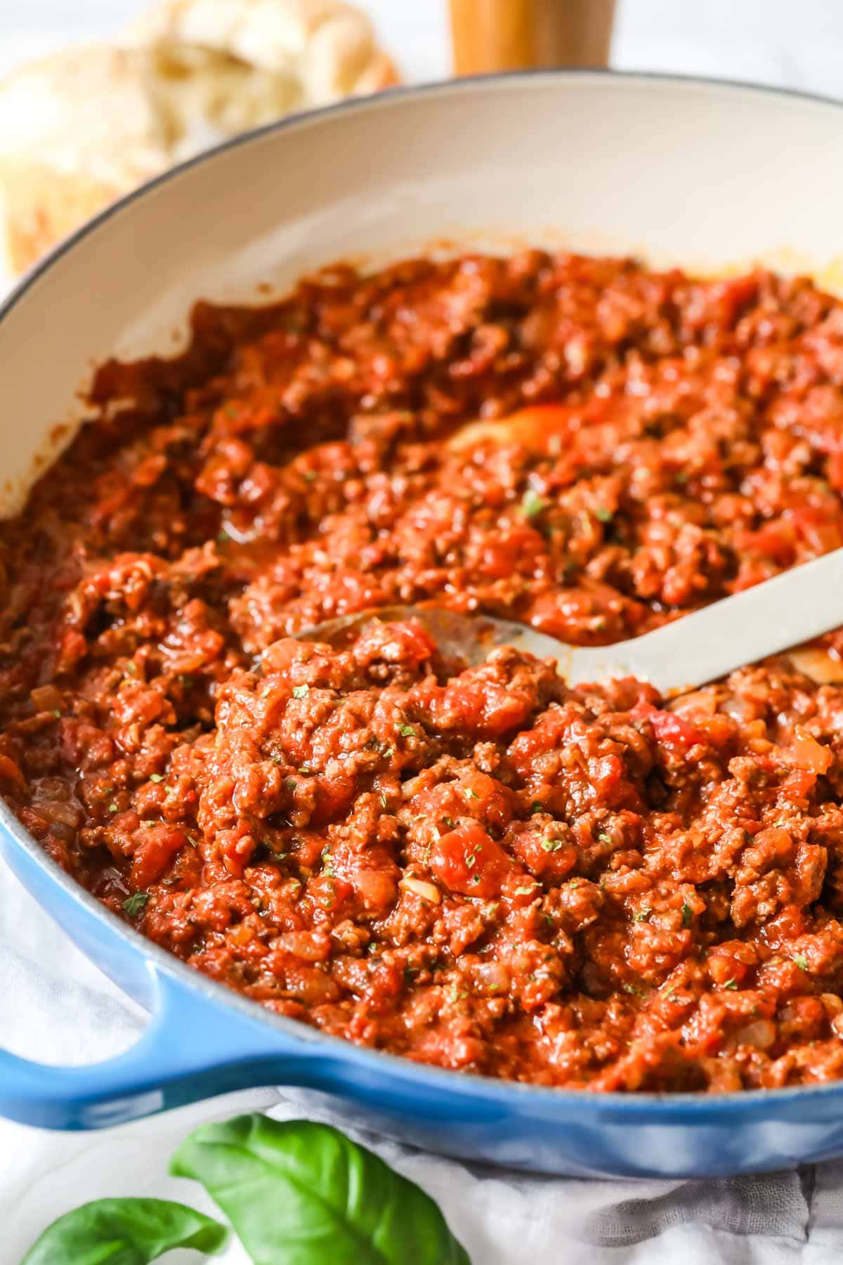 Close up view of a cast iron pan of meat sauce.