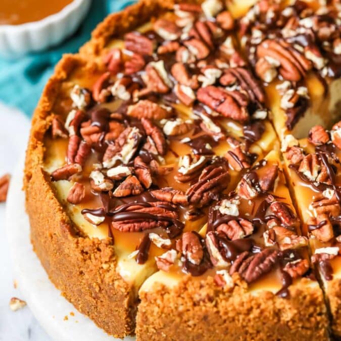 Turtle cheesecake with one slice cut but not removed.