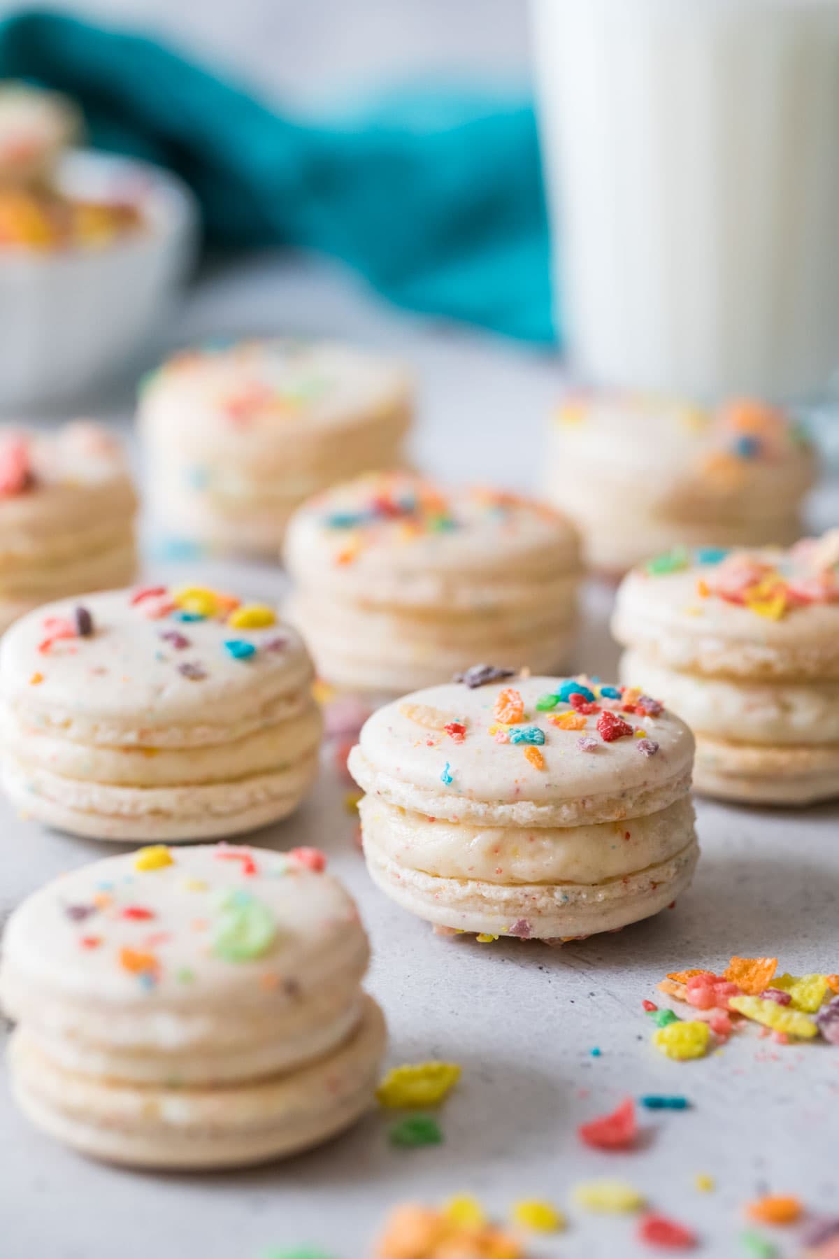 Macarons made with fruity pebbles arranged on a white countertop.