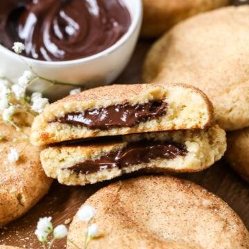 Two halves of a chocolate filled churro cookie among other cookies.