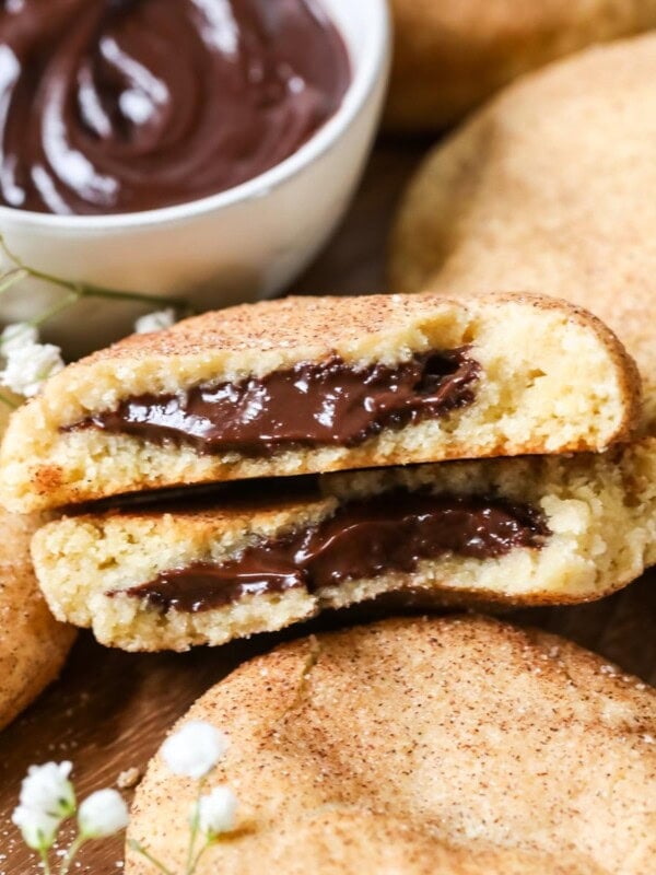 Two halves of a chocolate filled churro cookie among other cookies.