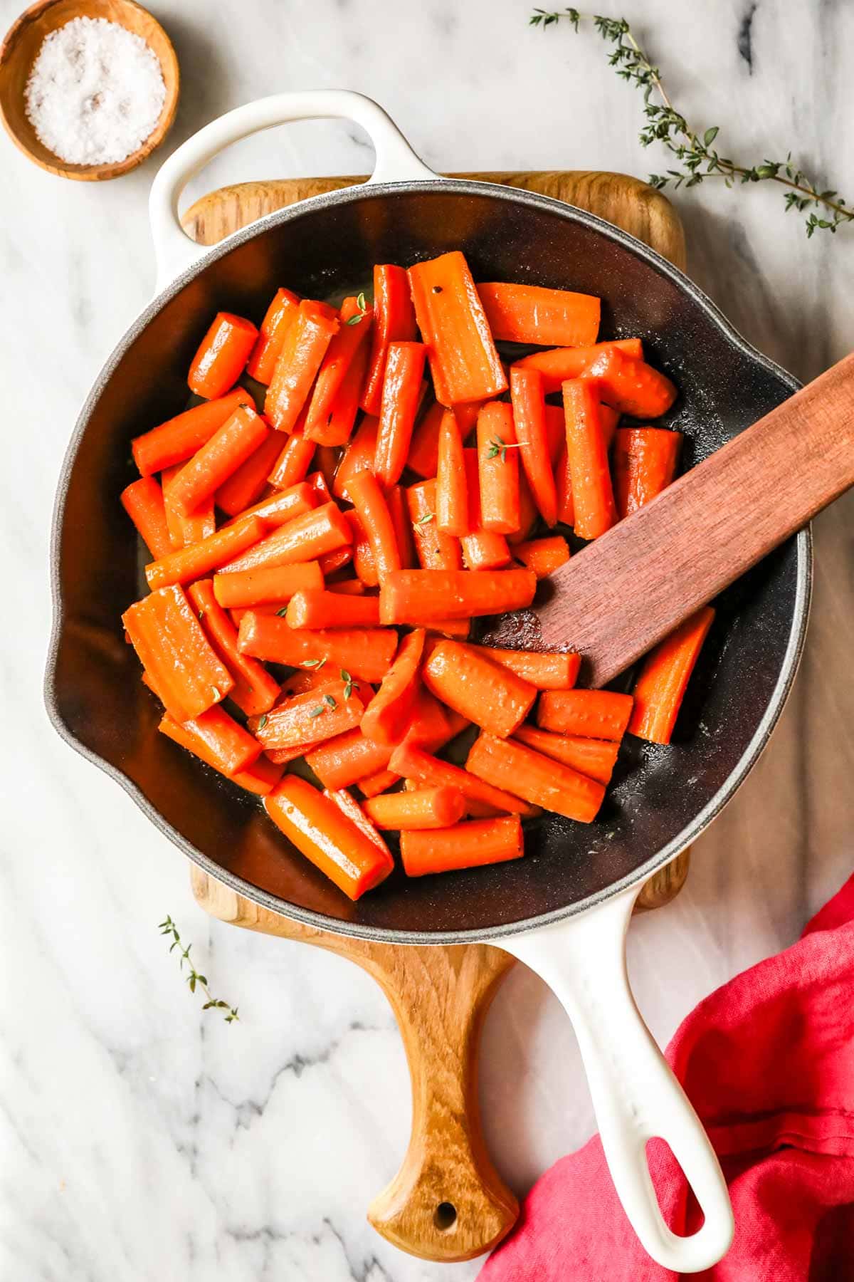 Overhead view of glazed carrots in a cast iron pan.