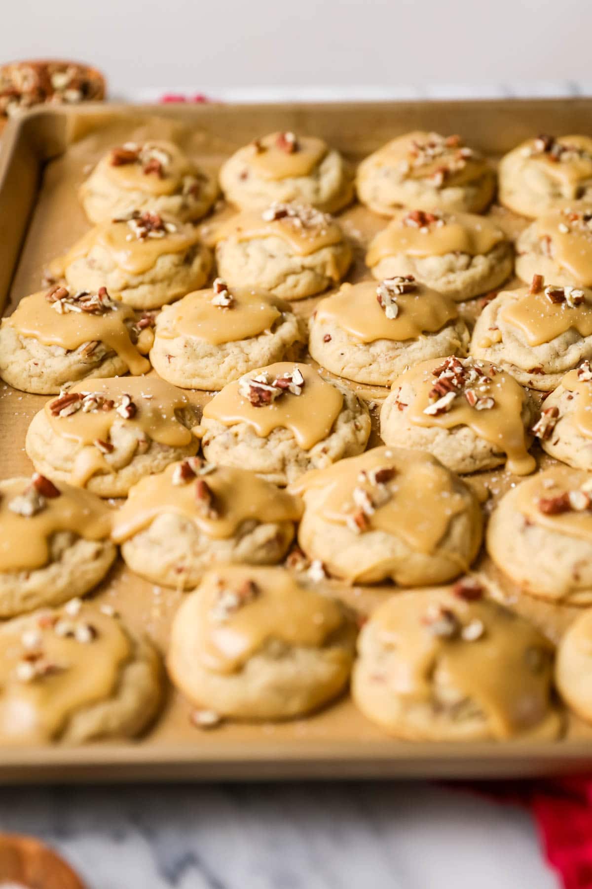 Rows of praline cookies topped with pecan pieces.