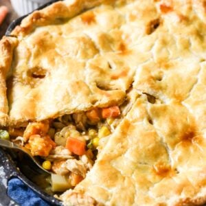 Close-up view of a turkey pot pie with one slice missing.