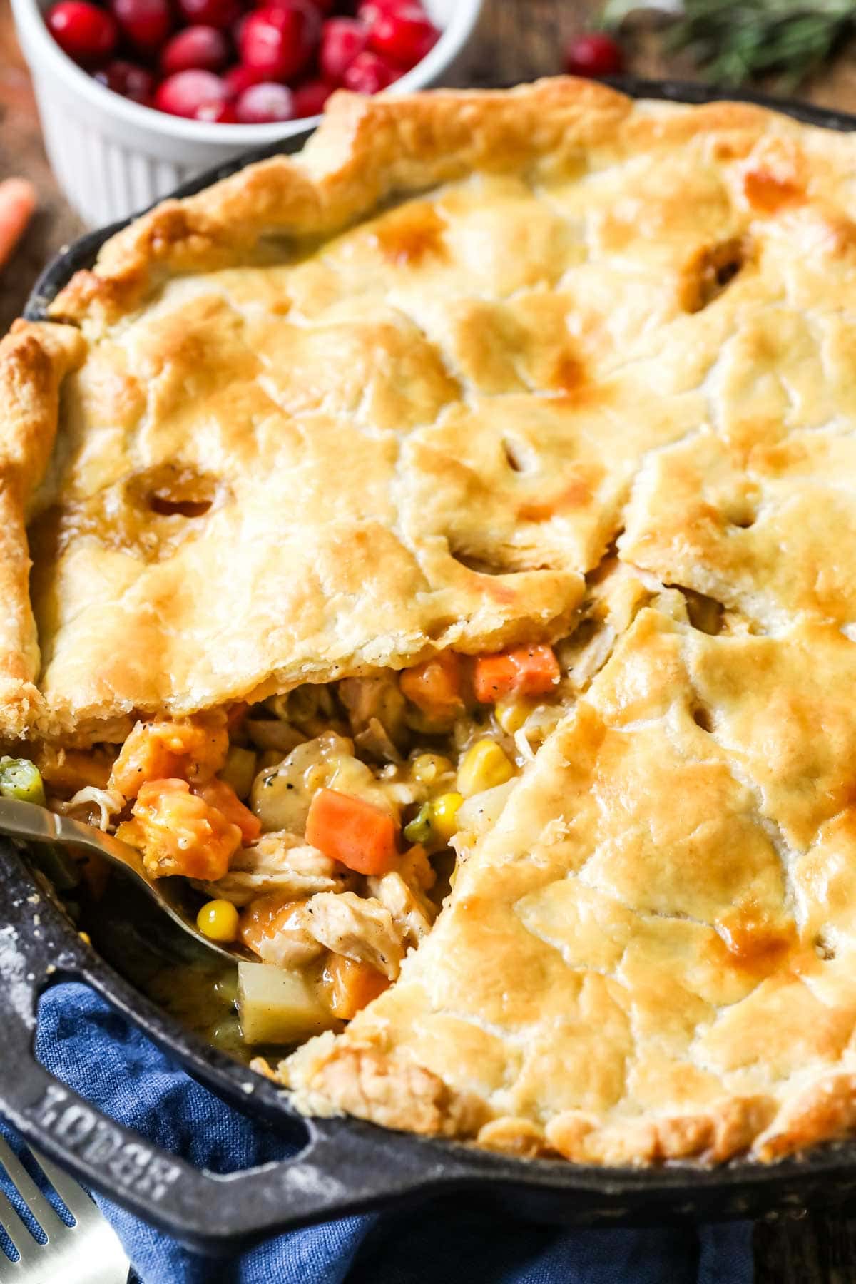 Turkey pot pie made in a cast iron pan with one slice missing.