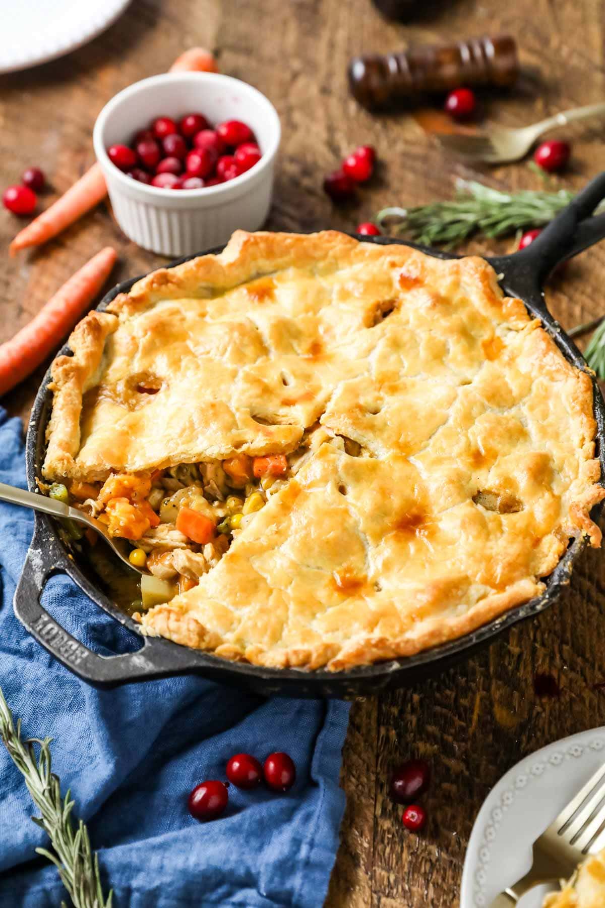 Turkey pot pie made in a cast iron pan with one slice missing.