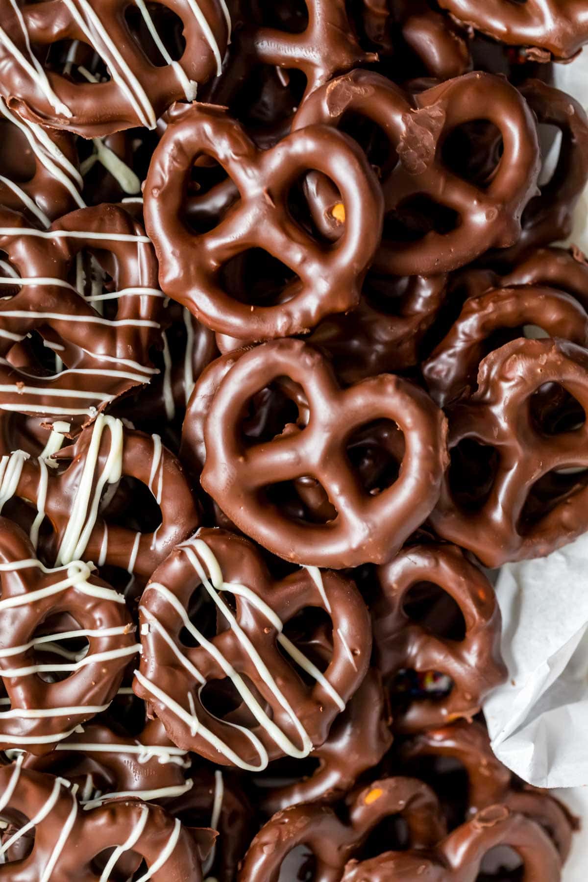 Close up view of chocolate dipped pretzels, some drizzled with white chocolate.