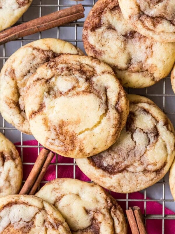 Overhead view of cinnamon cookies on a cooling rack with cinnamon sticks here and there.