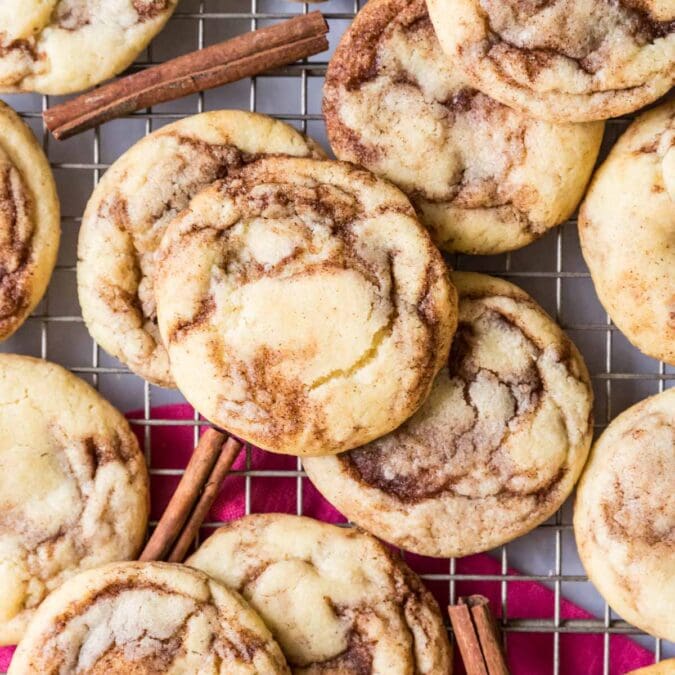 Overhead view of cinnamon cookies on a cooling rack with cinnamon sticks here and there.