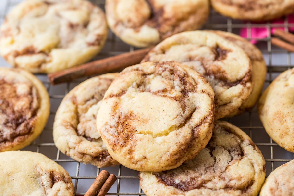 Cinnamon cookies on a cooling rack with cinnamon sticks arranged throughout.