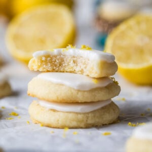 Stack of three lemon meltaway cookies with the top cookie missing a bite.