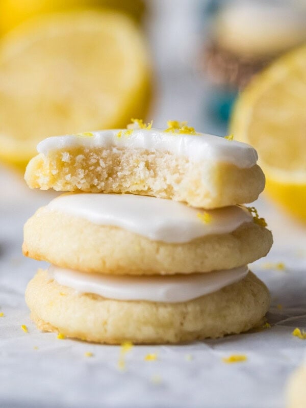 Stack of three lemon meltaway cookies with the top cookie missing a bite.