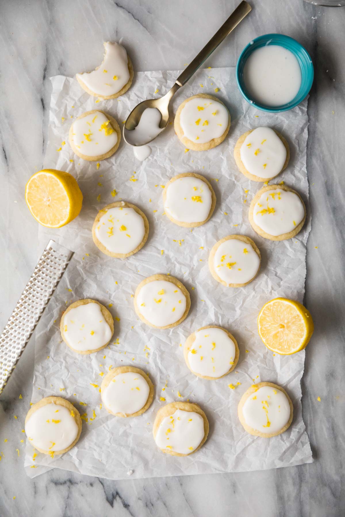 Overhead view of small lemon cookies topped with icing and lemon zest.