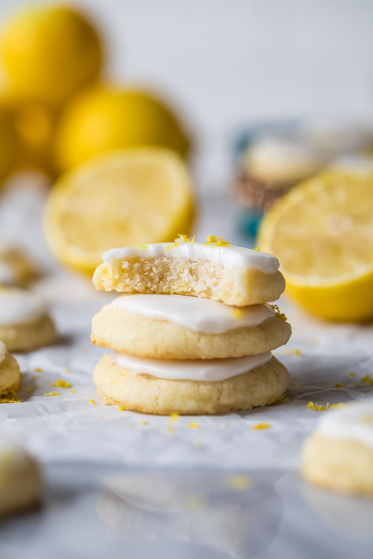 Stack of three lemon meltaway cookies with the top cookie missing a bite.