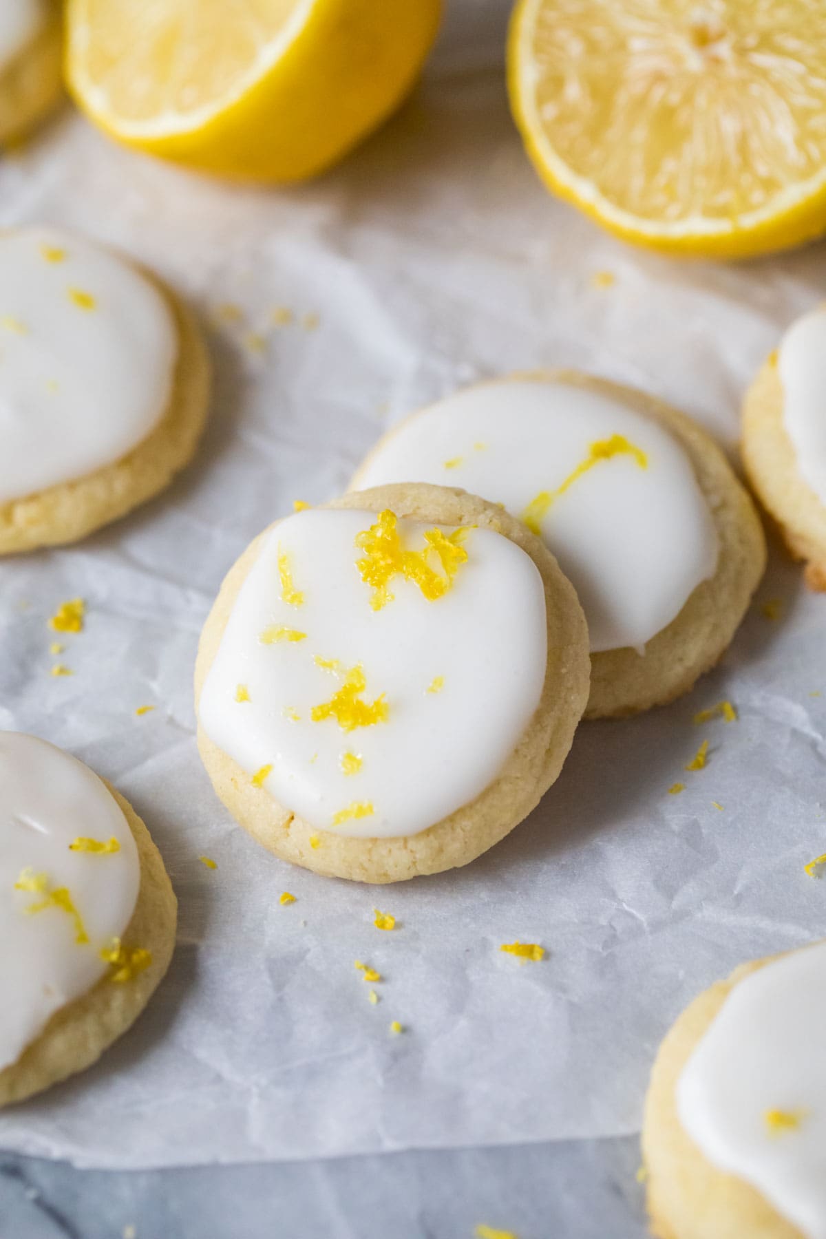 Overhead view of two lemon meltaway cookies topped with icing and lemon zest.