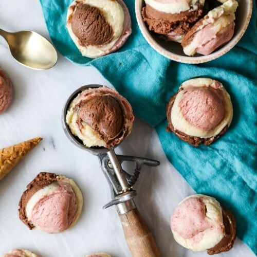 Neapolitan cookies scattered across a countertop with one cookie resting in an ice cream scoop.