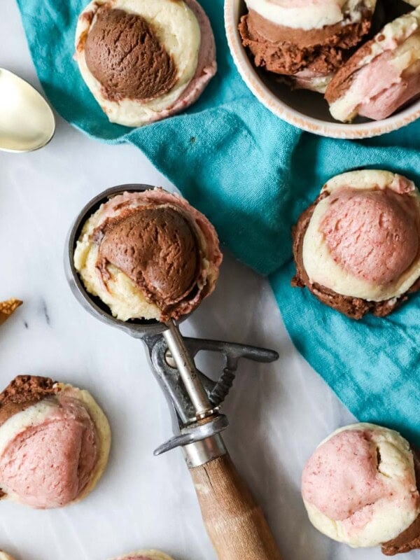 Neapolitan cookies scattered across a countertop with one cookie resting in an ice cream scoop.