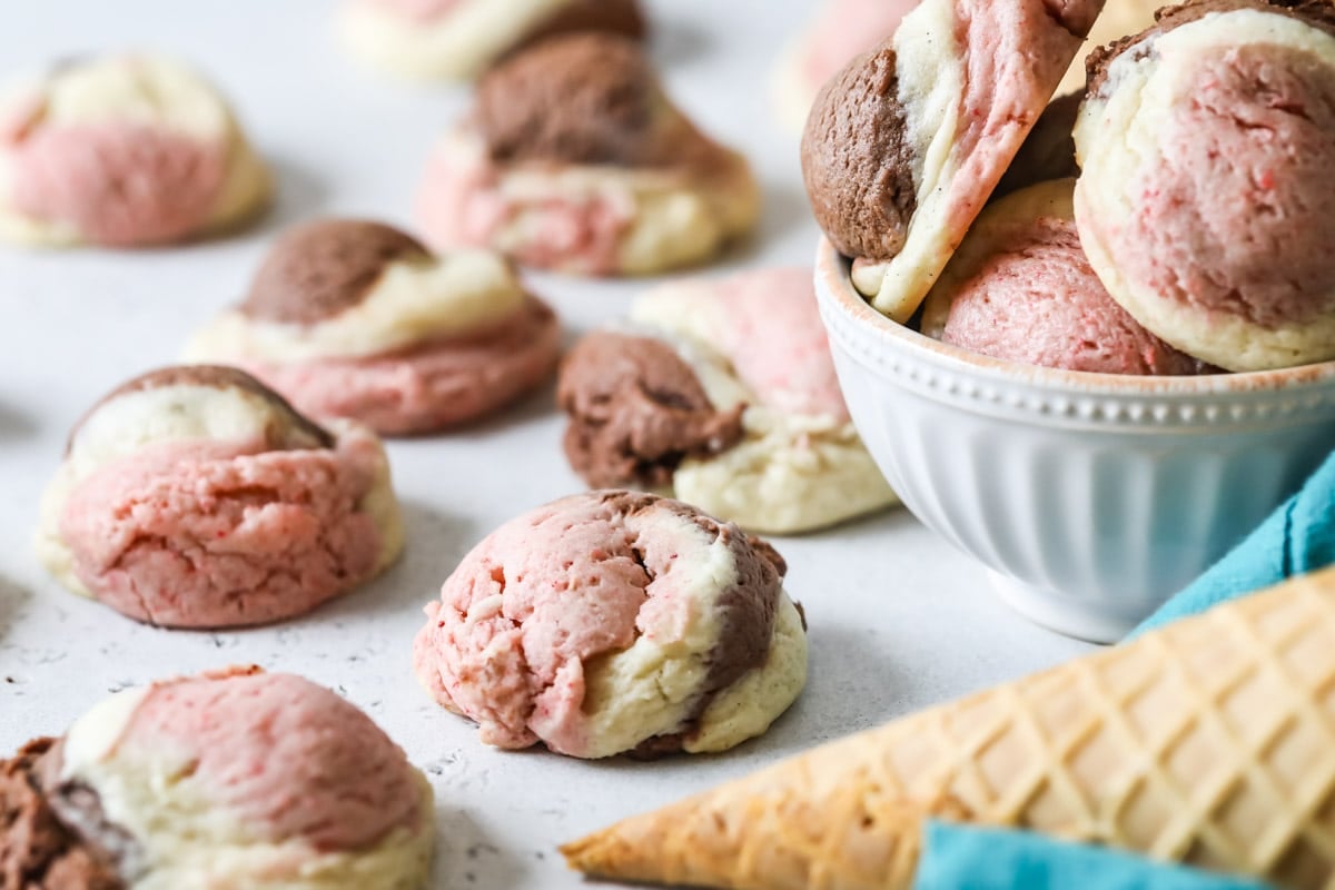 Close up view of a pink, white, and brown cookie made to look like ice cream.