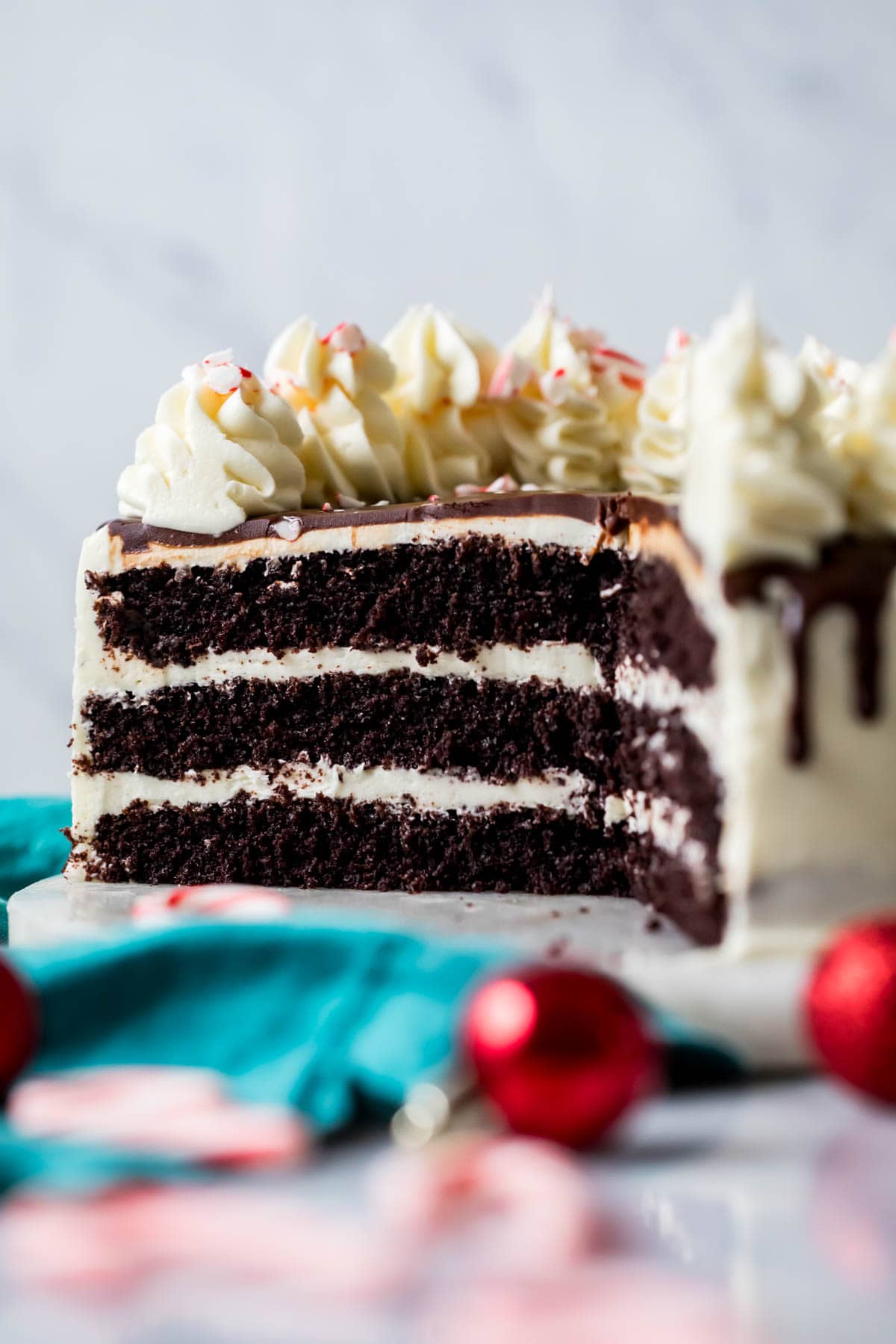 Cross section of a peppermint bark cake made with three layers of chocolate cake and a white chocolate peppermint buttercream.