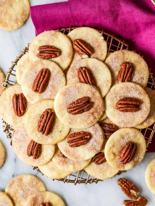 Overhead view of sand tarts made with pecans arranged on a cooling rack.