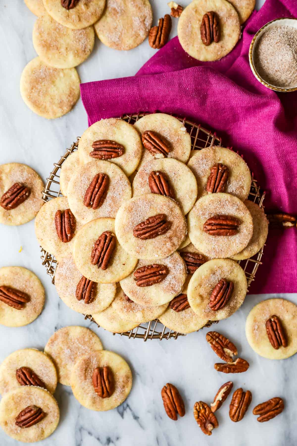 Overhead view of sand tarts made with pecans arranged on a cooling rack.