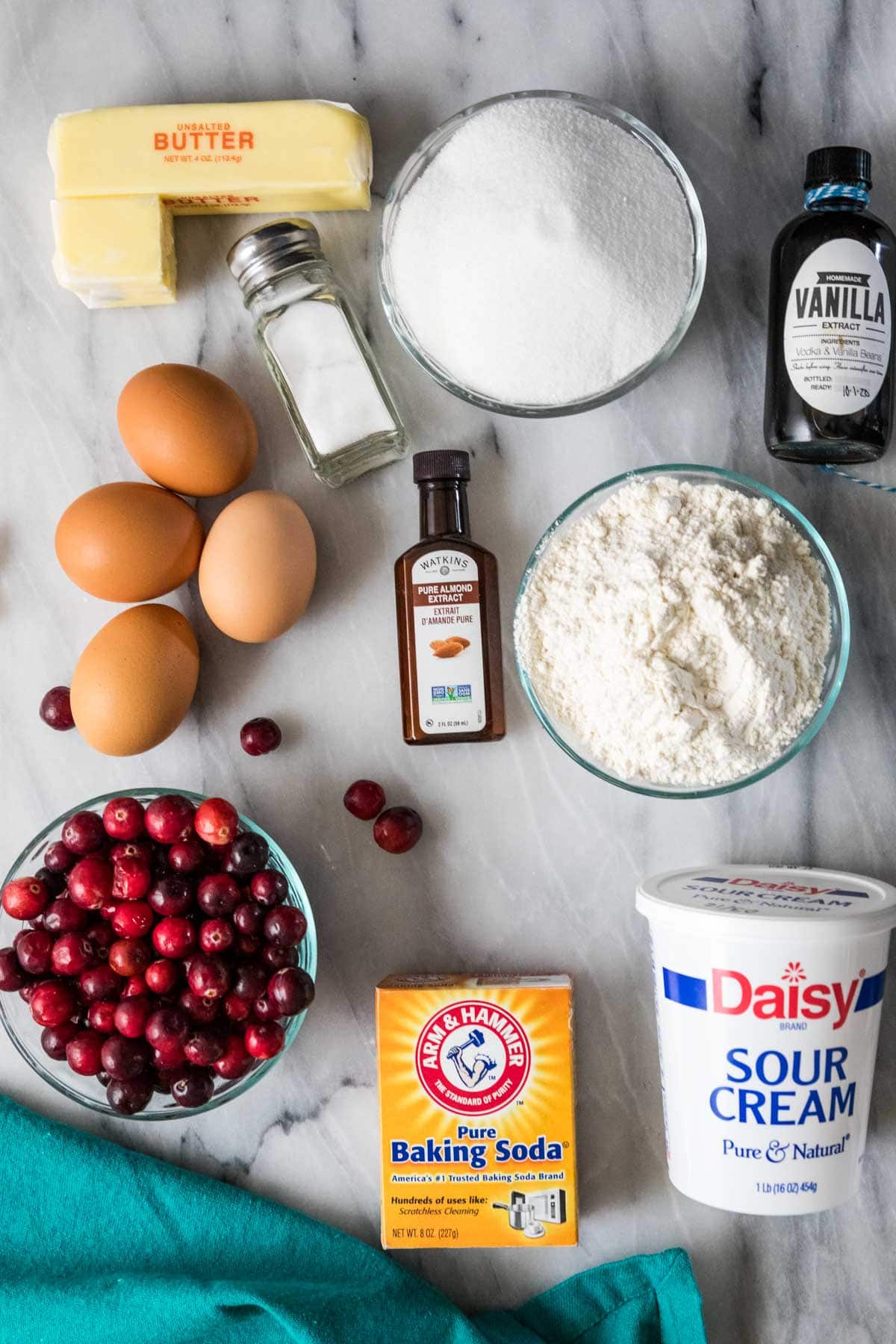 Overhead view of ingredients including cranberries, sour cream, eggs, almond extract, and more.