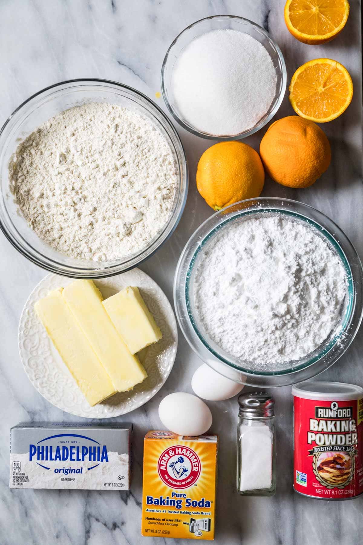 Overhead view of ingredients including oranges, cream cheese, eggs, and more.