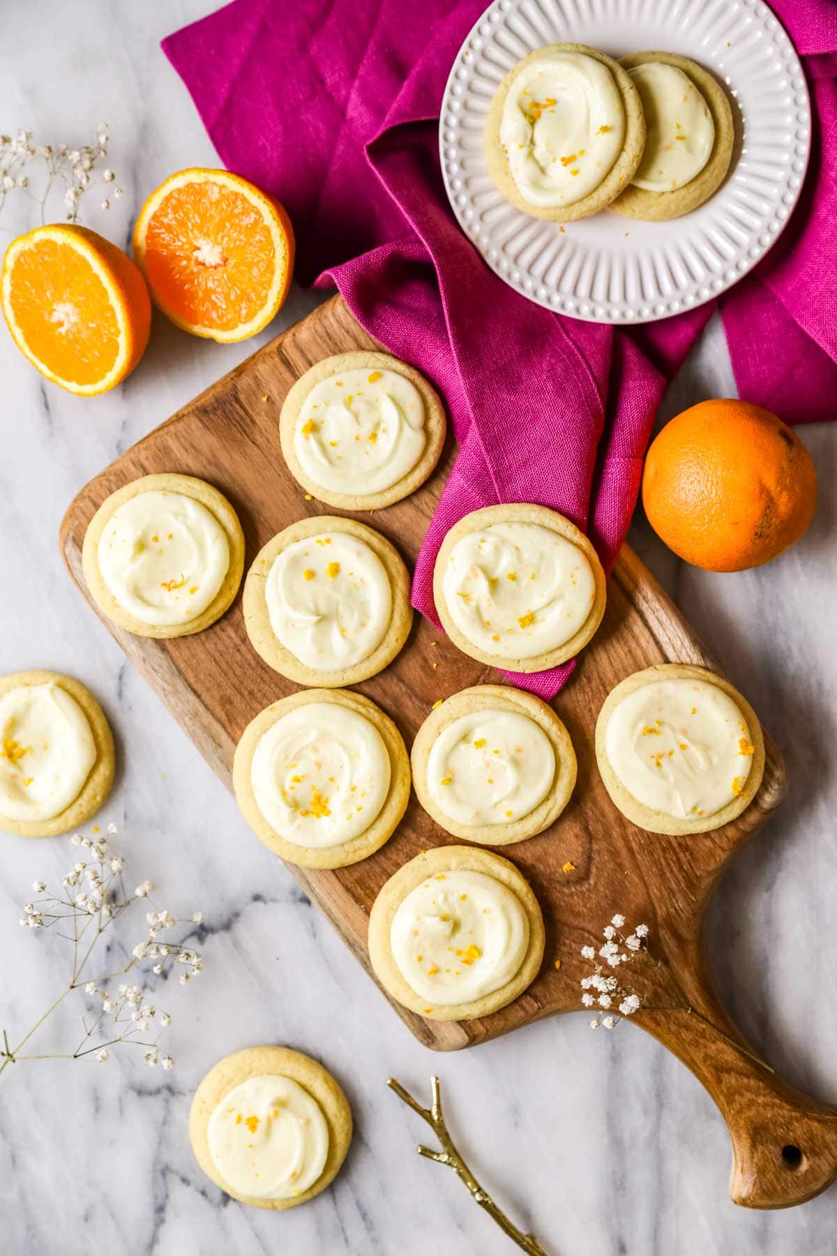 Overhead view of round cookies topped with an orange frosting and orange zest.