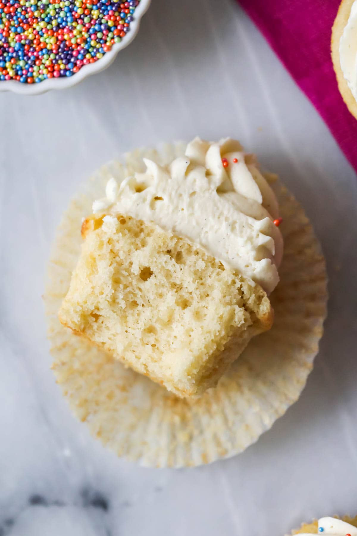 Vanilla cupcake that's been unwrapped and cut in half.