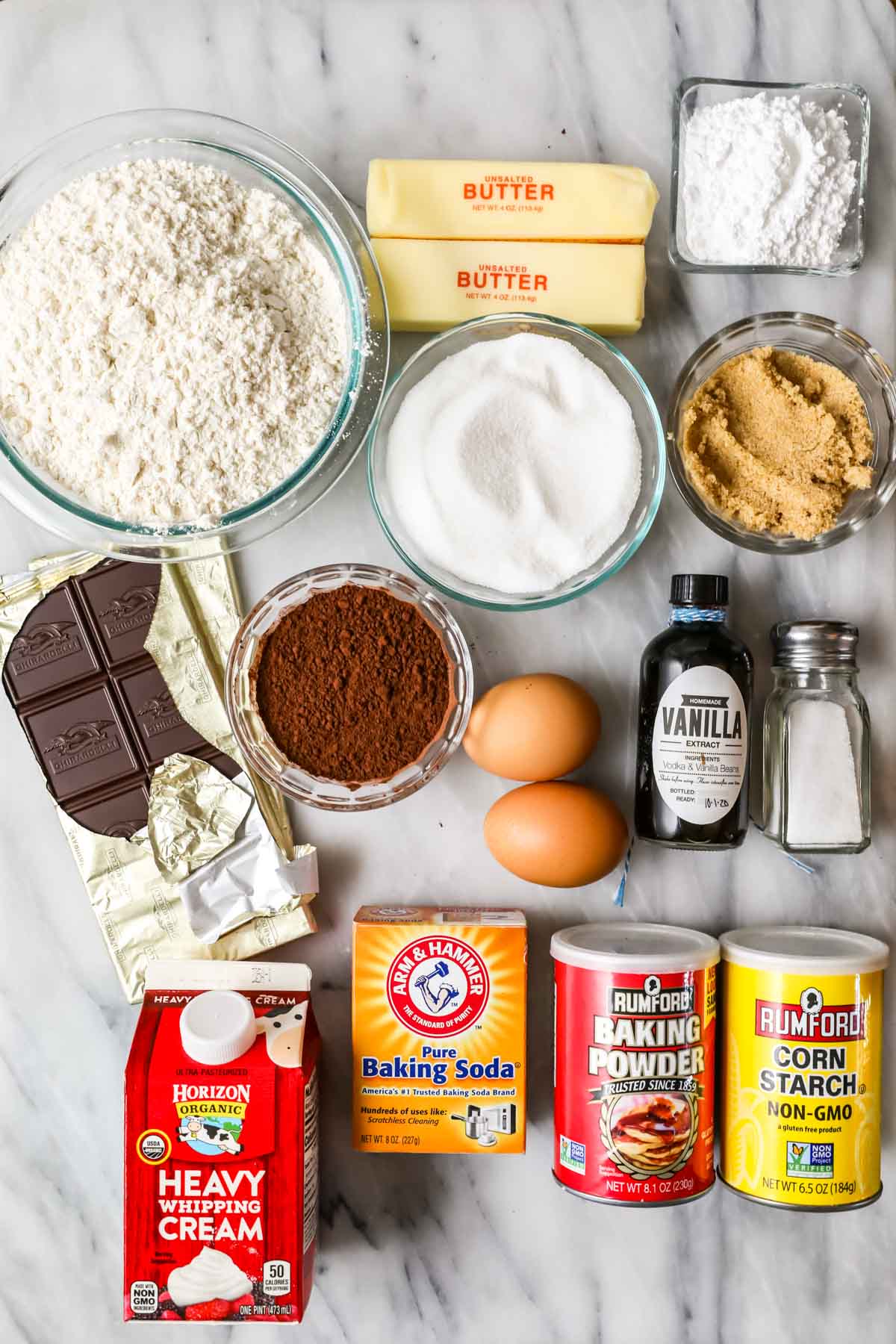 Overhead view of ingredients including chocolate, cocoa powder, flour, and more.