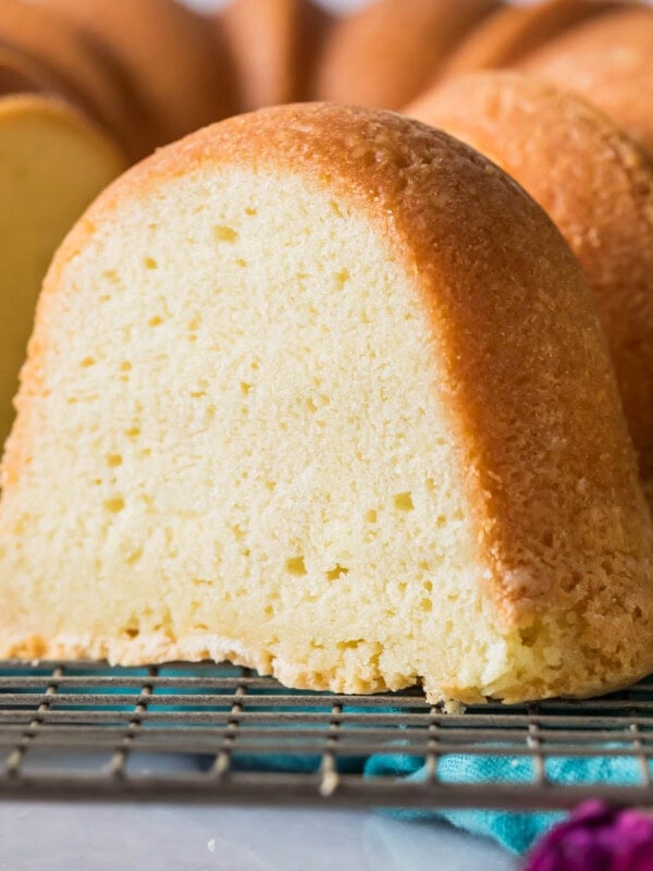 Slice of cream cheese pound cake with the remaining cake behind it.