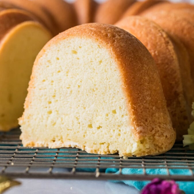 Slice of cream cheese pound cake with the remaining cake behind it.
