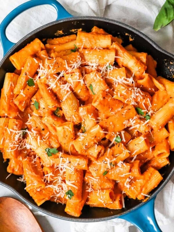Overhead view of pink sauce pasta in a blue cast iron skillet.