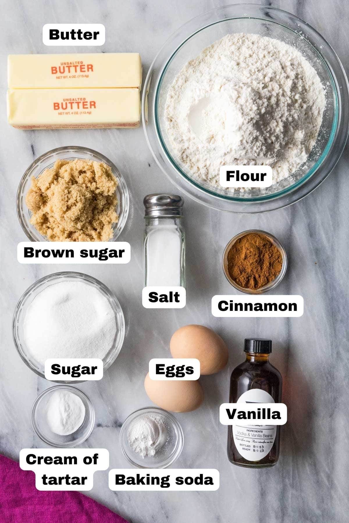 Overhead view of labelled ingredients including butter, cinnamon, cream of tartar, and more.