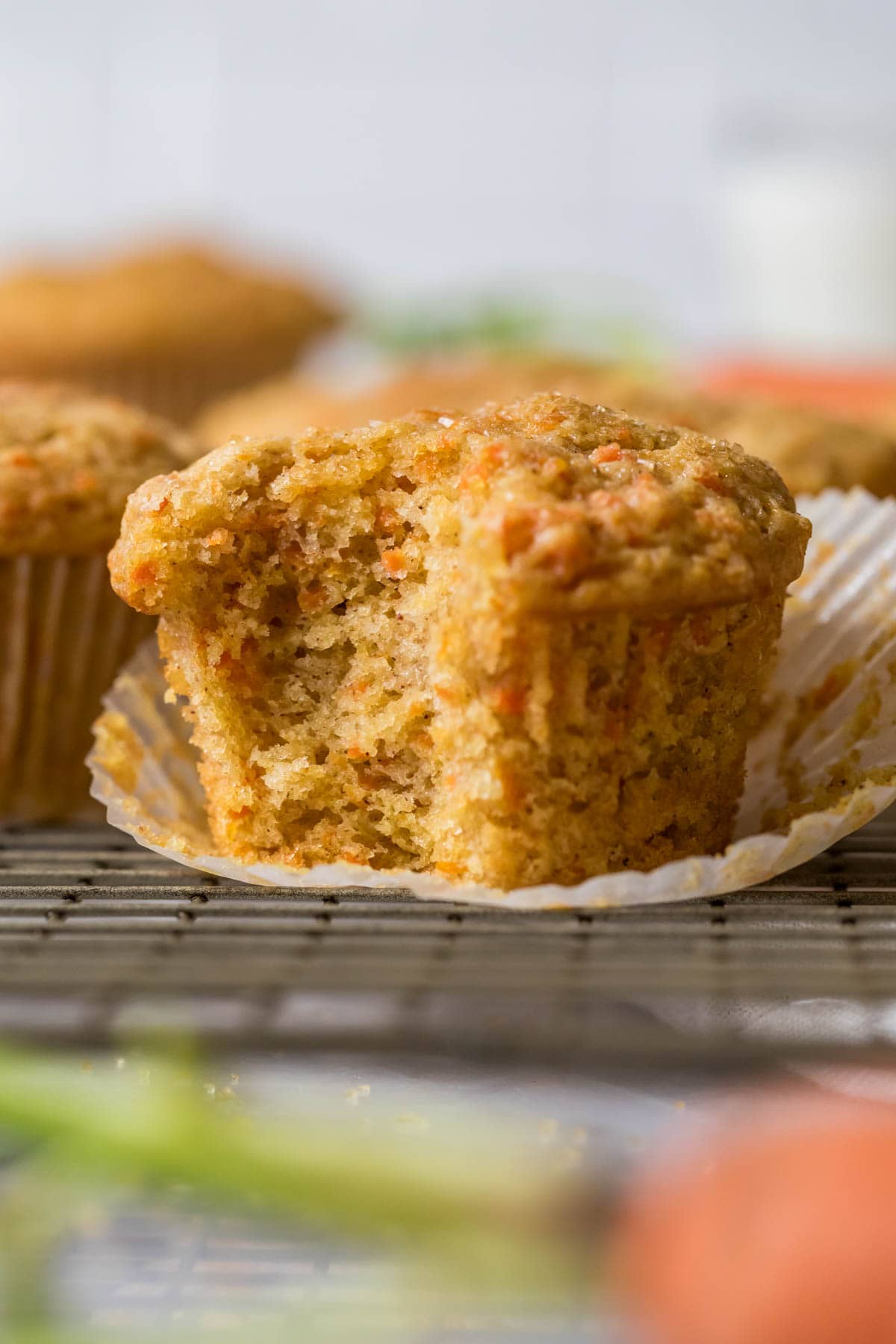 Close-up view of a muffin made with carrots that's been unwrapped and bitten.