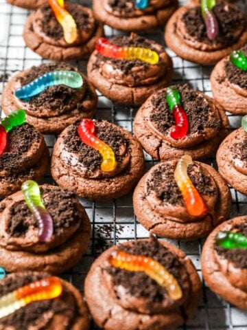 Cooling rack of dirt cookies topped with gummy worms.