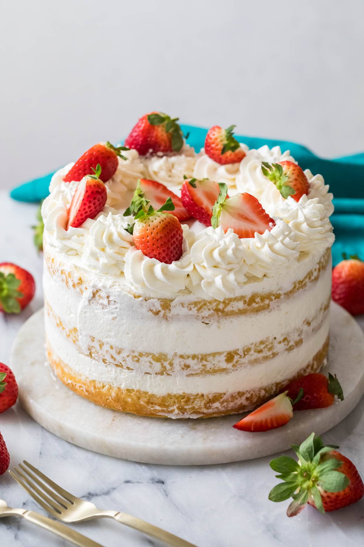 Strawberry shortcake cake decorated with whipped cream frosting and fresh berries.
