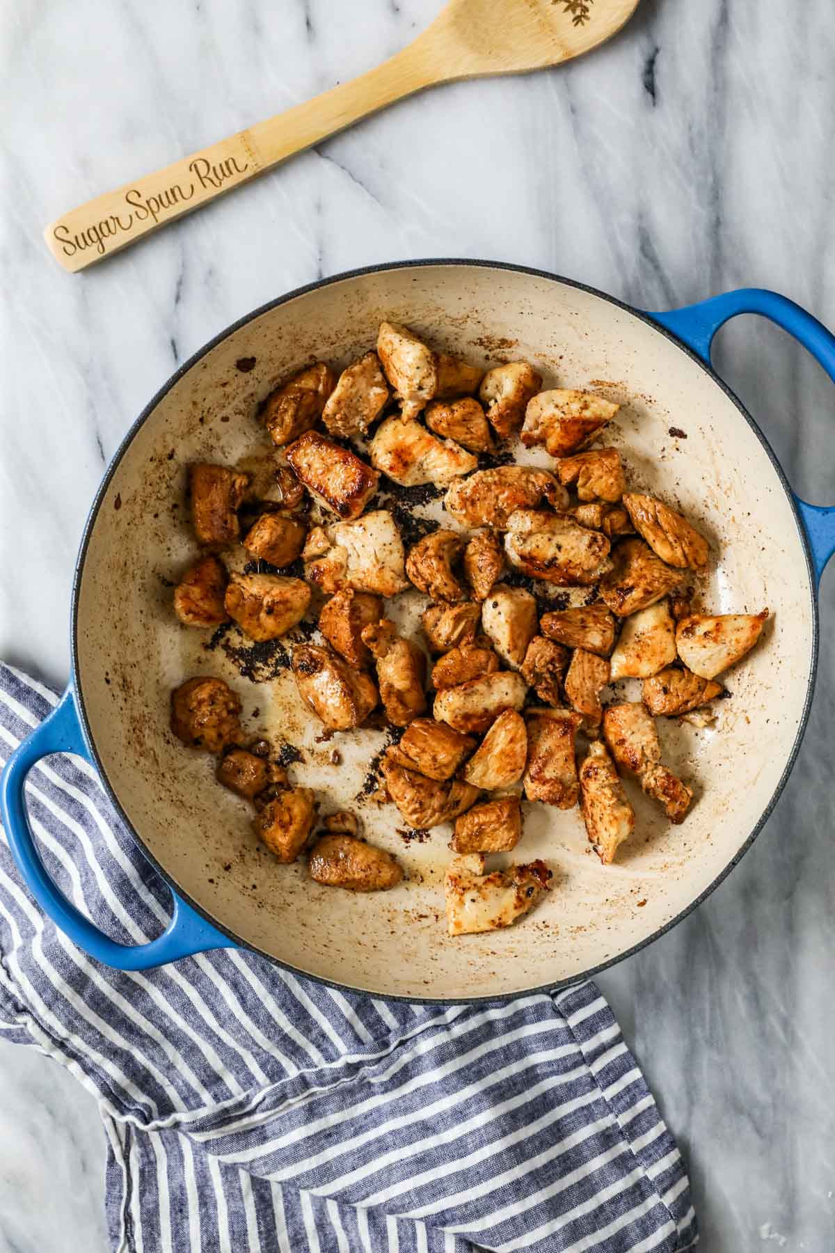 Overhead view of seared chicken breast pieces in a pan.