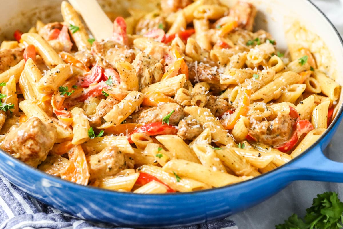 Close-up view of pasta, chicken, and veggies tossed in a creamy cajun sauce.