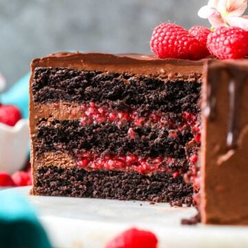 Cross section of a chocolate raspberry cake made with a raspberry filling and chocolate ganache topping.