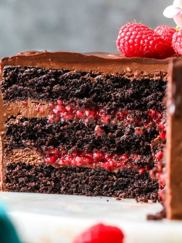 Cross section of a chocolate raspberry cake made with a raspberry filling and chocolate ganache topping.