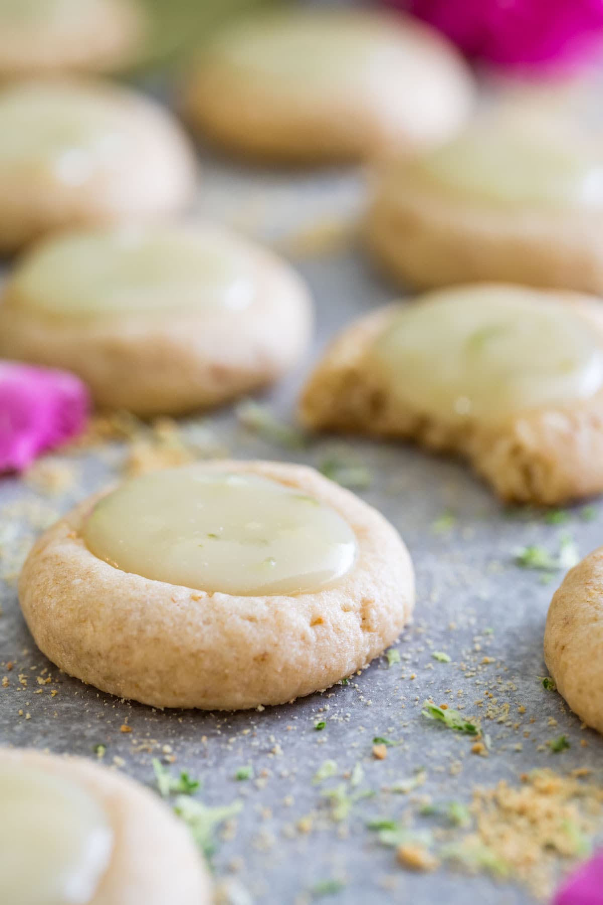 Key lime thumbprint cookies on a marble surface.