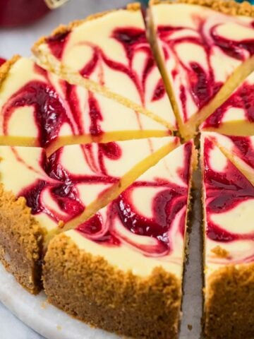 Slices of raspberry cheesecake on a serving platter.