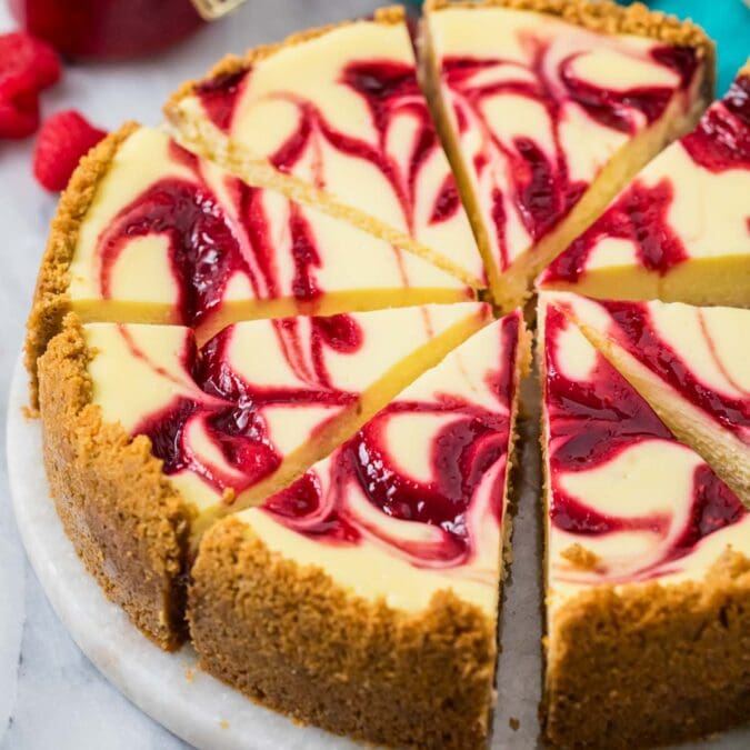 Slices of raspberry cheesecake on a serving platter.