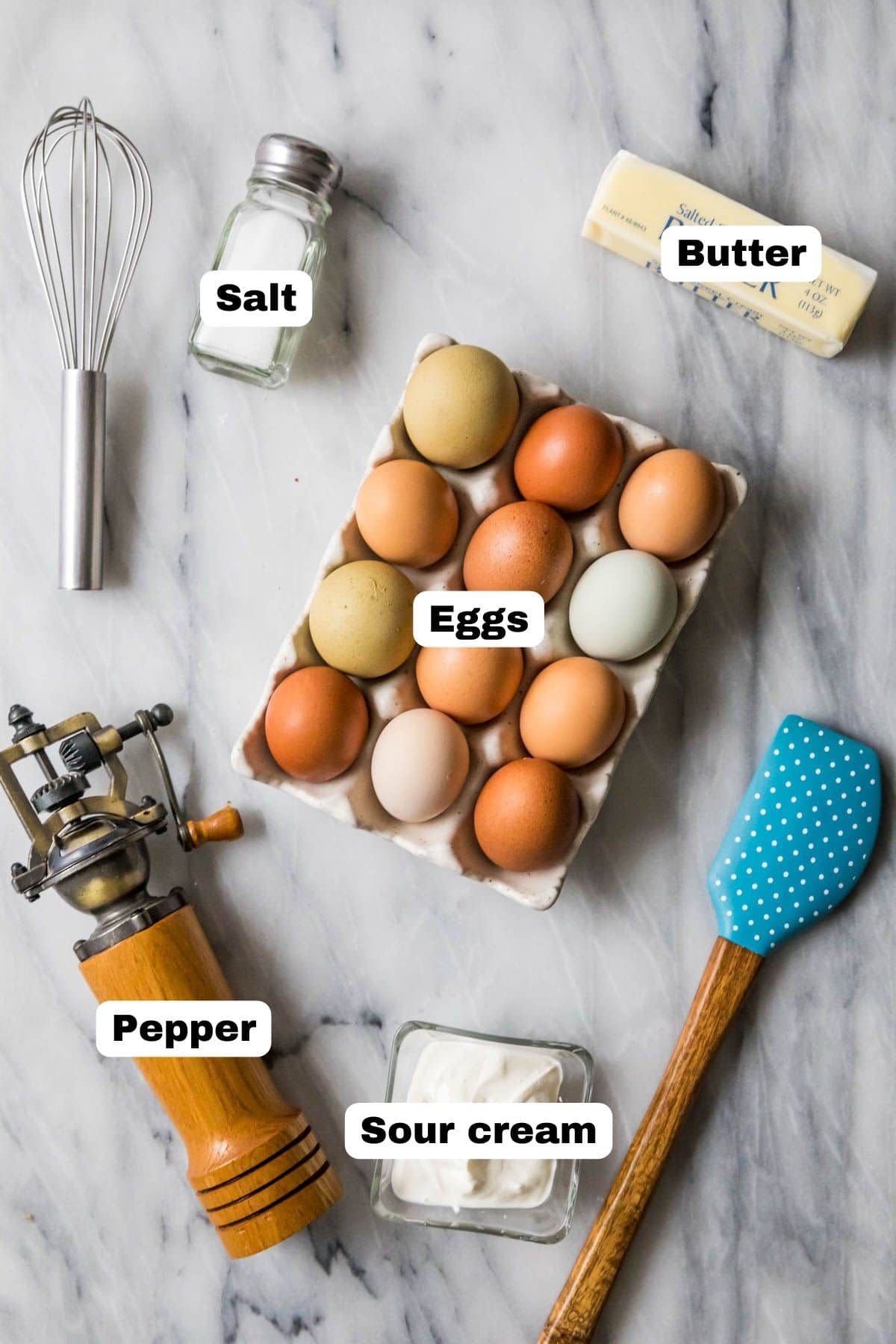 Overhead view of labeled ingredients including eggs, butter, salt, pepper, and sour cream.