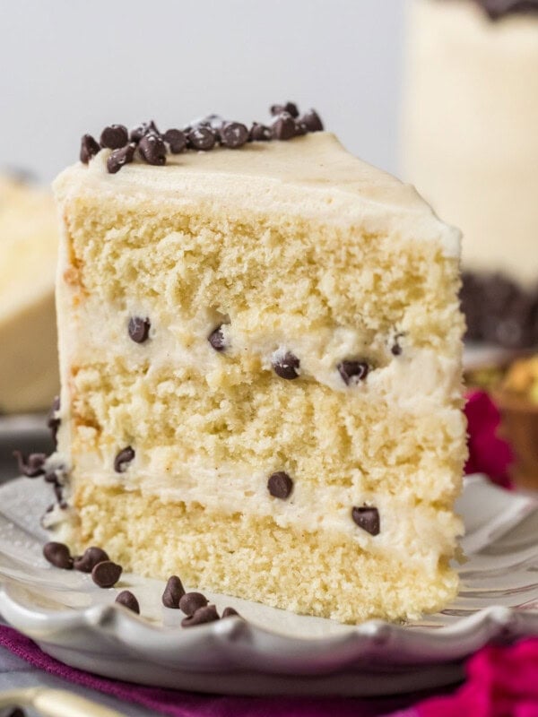 Slice of cannoli cake standing on a white plate.